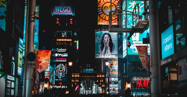 A cityscape of billboards showing different adverts above the heads of a crowd of shoppers A cityscape of billboards showing different adverts above the heads of a crowd of shoppers