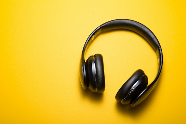 A pair of headphones on a yellow background A pair of headphones on a yellow background