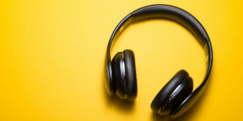 A pair of headphones on a yellow background A pair of headphones on a yellow background