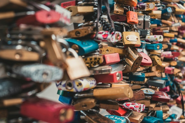Numerous colorful padlocks attached to a surface Numerous colorful padlocks attached to a surface
