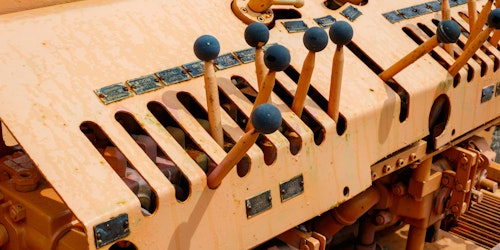 A series of levers with blue knobs on an old piece of machinery A series of levers with blue knobs on an old piece of machinery
