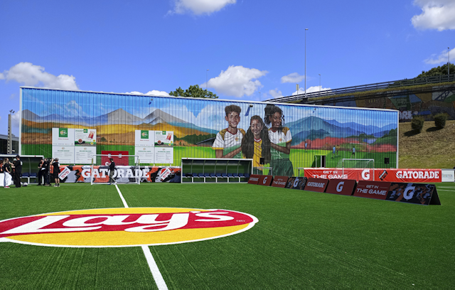 Lays and Gatorade branded football pitch with mural behind Lays and Gatorade branded football pitch with mural behind
