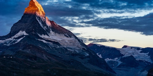 The sun-kissed snow-caps of a mountain The sun-kissed snow-caps of a mountain