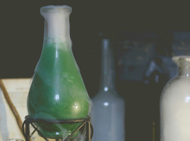 A glass flask containing a green liquid surrounded by a white vapour A glass flask containing a green liquid surrounded by a white vapour