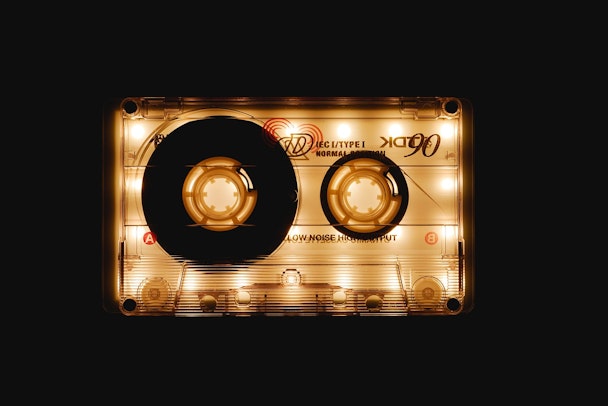 A casette tape is illuminated against a black background A casette tape is illuminated against a black background