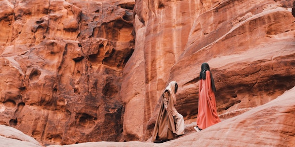Two people hiking across a mountain Two people hiking across a mountain
